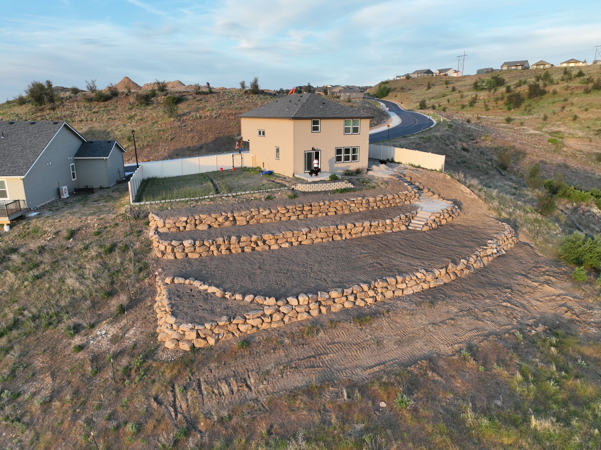 Tiered rock retaining walls on a hillside property built by Kevin Hatcher Excavation
